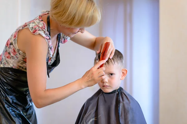 Hairdresser cutting a little boys hair — Stock Photo, Image