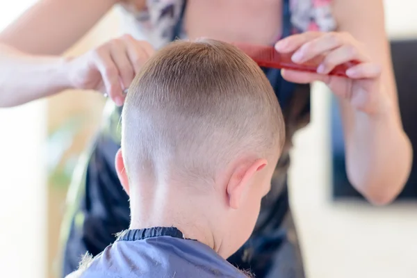 Coiffeur couper un jeune garçon cheveux — Photo