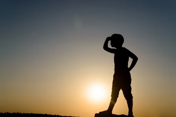 Silhouet van een jonge jongen op zoek in de verte — Stockfoto