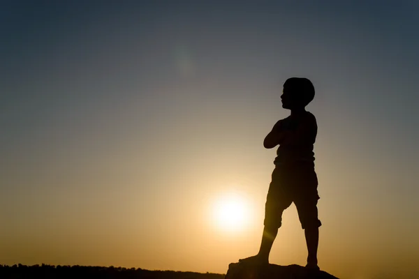 Silhouette di ragazzo in piedi con le mani sui fianchi — Foto Stock