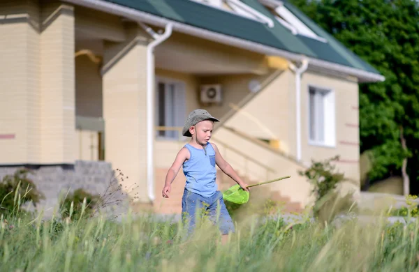 Mały chłopiec połowu owadów poza jego dom — Zdjęcie stockowe