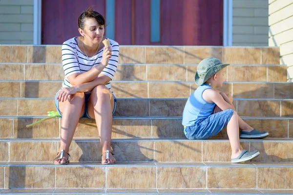 Vrouw eten van ijs in de buurt van mokkend Boy — Stockfoto