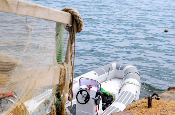 Räcke draperad i fisknät på docka med båt — Stockfoto