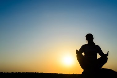 Meditasyon yükselen güneşin önünde kadın
