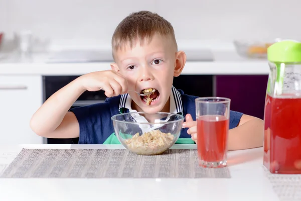 Chłopiec jedzenia płatków owsianych płatków na śniadanie — Zdjęcie stockowe