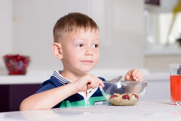 Pojken äta skål med flingor till frukost — Stockfoto
