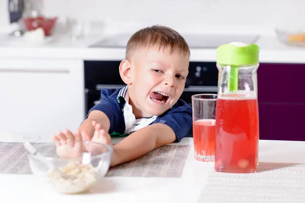 Pojke som driver bort skål med flingor till frukost — Stockfoto