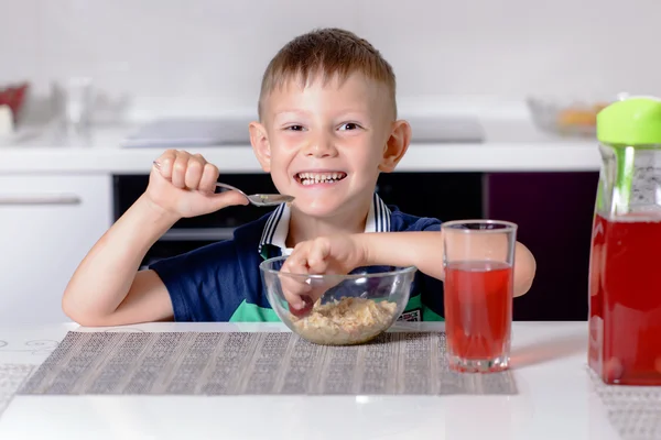 Felice sorridente giovane ragazzo mangiare il suo pranzo — Foto Stock