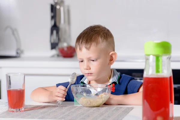 Kleiner Junge am Frühstückstisch isst Schale Müsli — Stockfoto