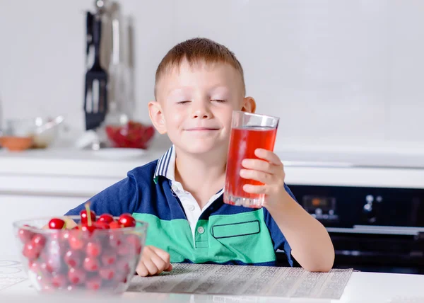 Jongen glas sap keuken aan tafel — Stockfoto