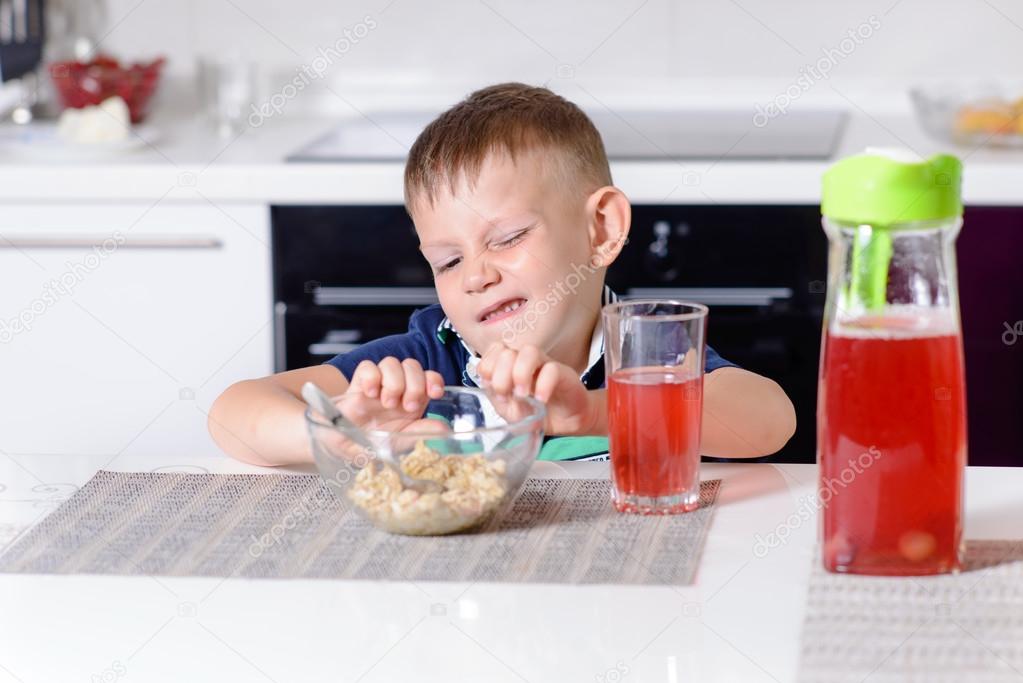 Young Boy Pushing Away Bowl of Breakfast Cereal