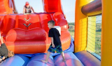Full length of boy playing on bouncy castle