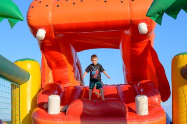 Boy Playing on Giant Red Inflatable Hippopotamus