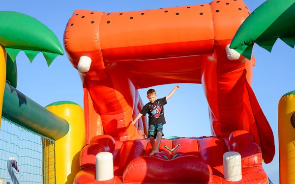 Ragazzo che gioca su ippopotamo gonfiabile rosso gigante — Foto Stock