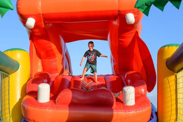 Boy Playing on Giant Red Inflatable Hippopotamus — стокове фото