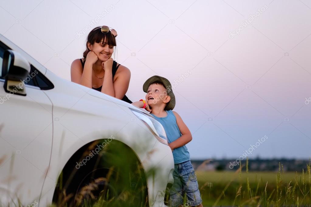 Mother and Son with Car in Field at Sunset