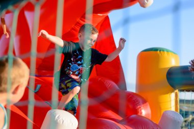 Small boy playing on bouncy castle