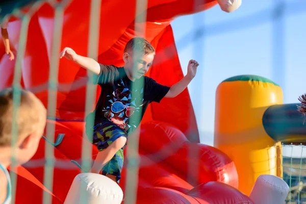 Menino pequeno jogando no castelo bouncy — Fotografia de Stock