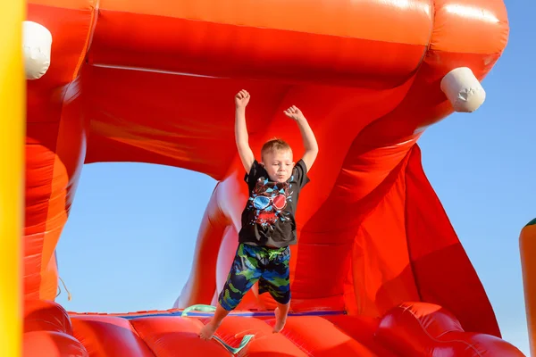 Мальчик прыгает на пластиковом прыгающем замке — стоковое фото