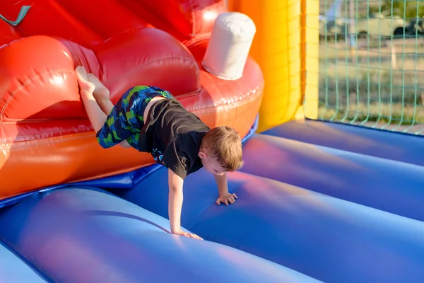 Jeune garçon se baladant sur un château sautant — Photo