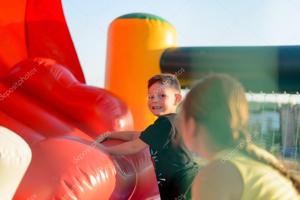 Two children playing on red bouncy castle