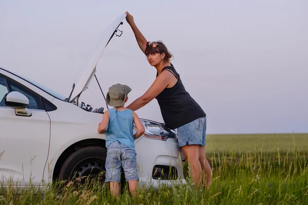 Mamá con hijo abriendo la parte delantera del coche defectuoso — Foto de Stock