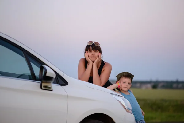 Mãe e filho se apoiando na frente do carro branco — Fotografia de Stock