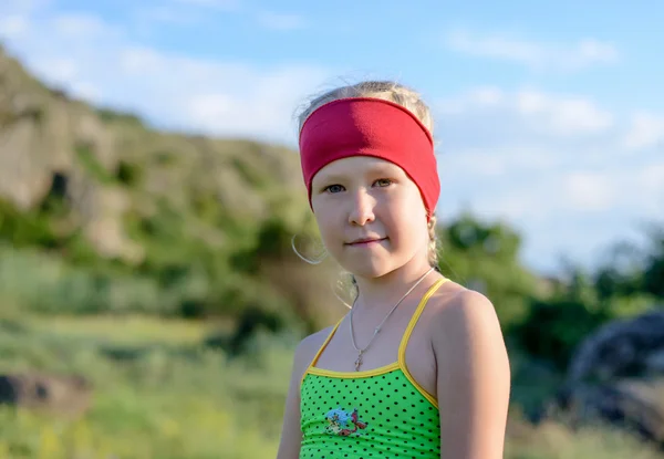 Fille mignonne avec bandeau rouge sourire à la caméra — Photo