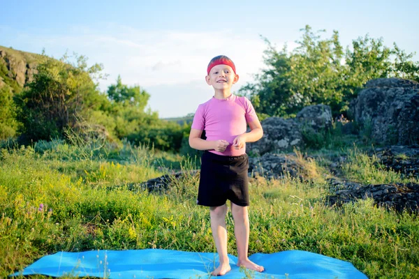 Kid in Fitness Attire Stands on Mat at the Grasses — Stock Photo, Image