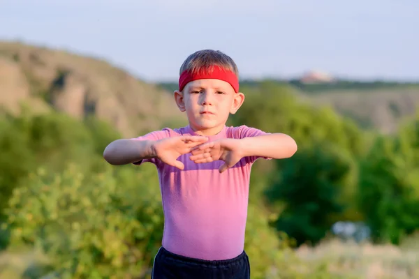 Niño feliz practicando artes marciales se mueve al aire libre —  Fotos de Stock