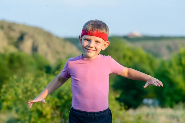 Niño feliz practicando artes marciales se mueve al aire libre — Foto de Stock