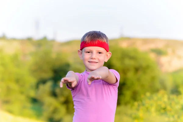 Cute Boy on Grassy Ground in Arms Forward Position — Stock Photo, Image