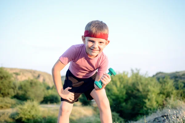 Healthy Boy Leans Forward While Lifting Weights — Stockfoto