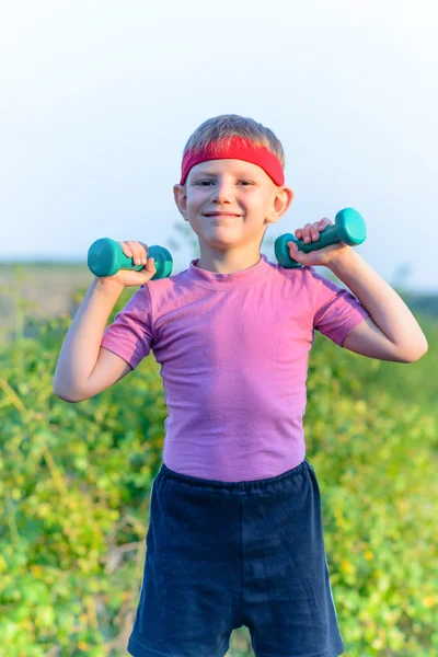 Strong Boy Lifting Two Small Dumbbells — Stockfoto