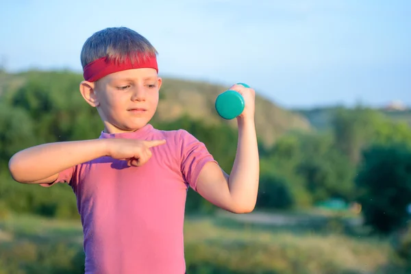 Boy Lifting Dumbbell and Pointing his Arm Muscles — 图库照片