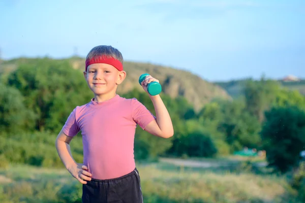 Cute Boy Lifting Dumbbell with Right Hand on Waist — Stockfoto