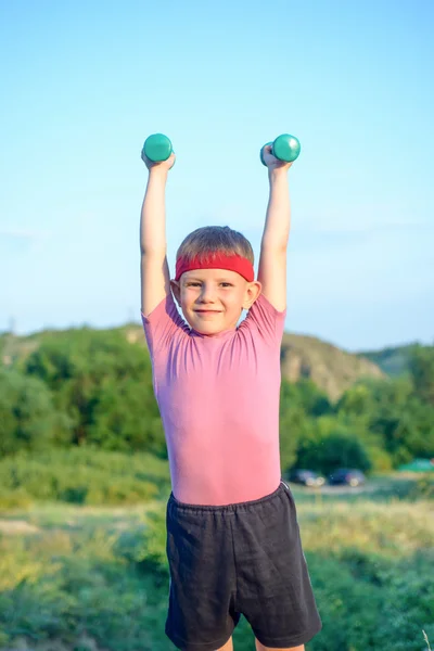 Smiling Strong Boy Raising Two Dumbbells — Stockfoto