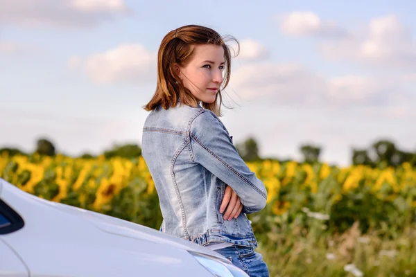 Pensive menina bonita encostada às costas contra o carro — Fotografia de Stock