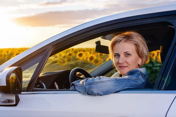 Женщина в машине смотрит на камеру через окно — стоковое фото