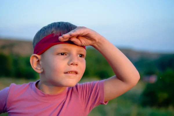 Маленький хлопчик заглянув на захід сонця — стокове фото