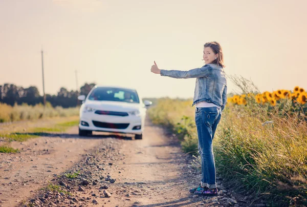 Woman hitchhiking on a rural road — Stock Photo, Image