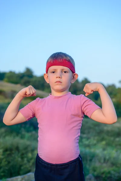 Menino mostrando seus bíceps — Fotografia de Stock