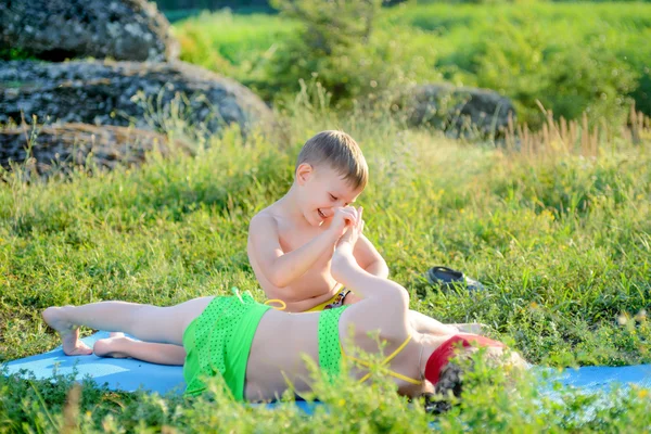 Feliz bonito crianças abraçando no tapete na grama — Fotografia de Stock