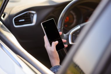 Girl reading a text message as she drives