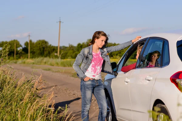 Woman standing chatting to her friend in a car — Stockfoto