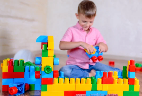 Young boy playing with colorful building blocks — Stock Photo, Image