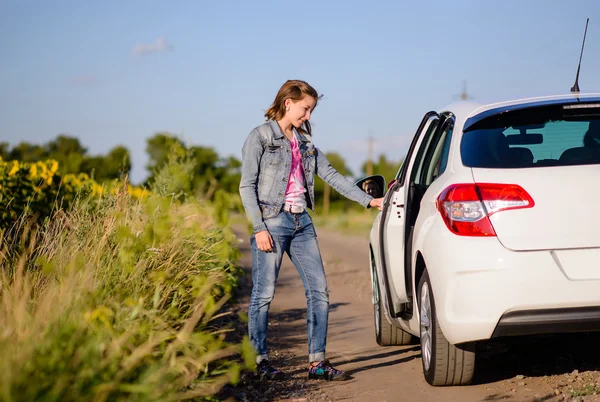 Genç kadın bir arabanın kapısını açarak — Stok fotoğraf