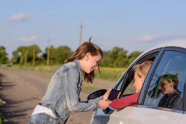 Bir kadın sürücü ile konuşmaya dostu genç kız — Stok fotoğraf