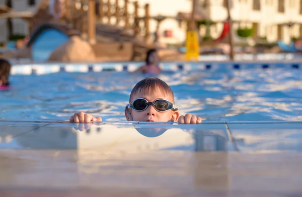 Rapaz a espreitar de uma piscina — Fotografia de Stock