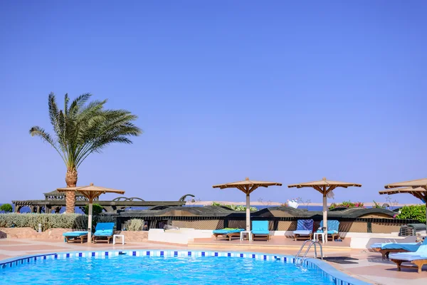 Swimming pool and umbrellas at a resort — Stockfoto